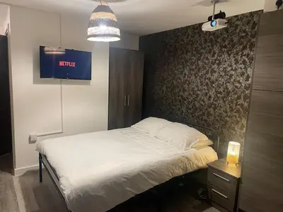 a bedroom with a bed and a tv on the wall at Radio City Apartments City Centre sleeps 4 in Liverpool