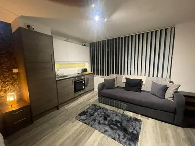a living room with a couch and a kitchen at Radio City Apartments City Centre sleeps 4 in Liverpool