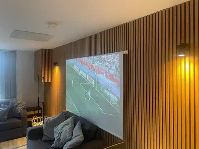a living room with a large screen tv on a wall at Radio City Apartments City Centre sleeps 4 in Liverpool
