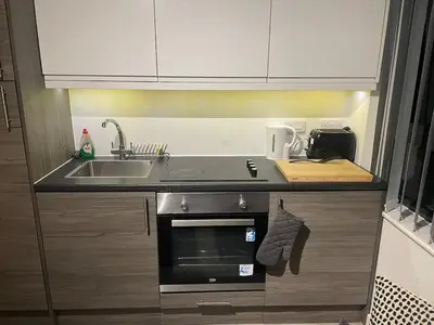a small kitchen with a sink and a stove at Radio City Apartments City Centre sleeps 4 in Liverpool