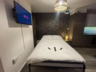 a bedroom with a bed with a tv on the wall at Radio City Apartments City Centre sleeps 4 in Liverpool