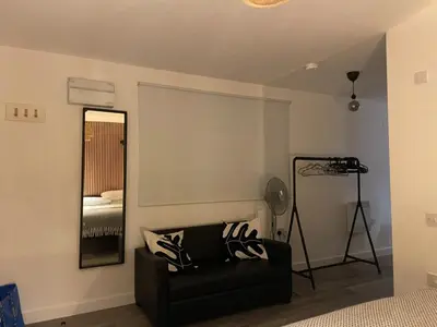 a room with a black couch and a mirror at Manhattan Apartment City Centre sleeps 4 in Liverpool