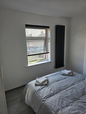 a bedroom with a bed with two towels on it at Woolfall heath avenue in Roby