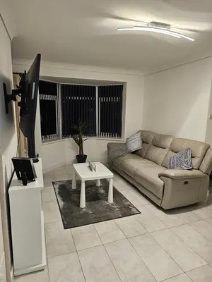 a living room with a couch and a table at Woolfall heath avenue in Roby