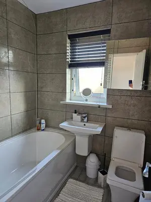 a bathroom with a tub and a sink and a toilet at Woolfall heath avenue in Roby