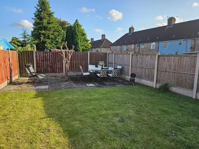 a backyard with a table and chairs and a fence at Woolfall heath avenue in Roby