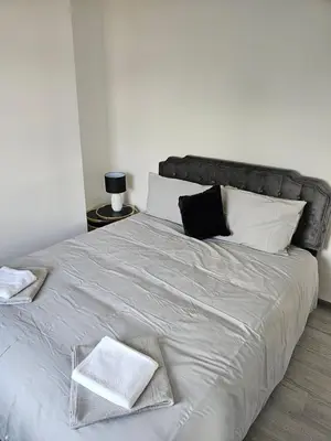 a white bed with two towels on top of it at Woolfall heath avenue in Roby