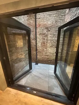 a glass window in a room with a brick wall at 10 Hockenhall - Liverpool's Oldest House in Liverpool