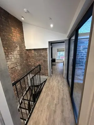 a hallway with a staircase and a brick wall at 10 Hockenhall - Liverpool's Oldest House in Liverpool