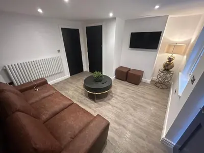 a living room with a brown couch and a table at 10 Hockenhall - Liverpool's Oldest House in Liverpool
