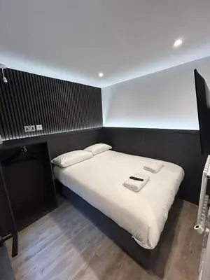 a bedroom with a large bed with white sheets at 10 Hockenhall - Liverpool's Oldest House in Liverpool
