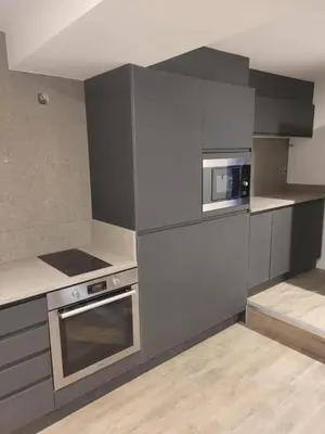 a kitchen with gray cabinets and a microwave and a stove at 10 Hockenhall - Liverpool's Oldest House in Liverpool
