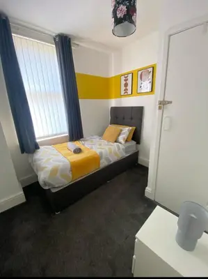 a small bedroom with a bed with a window at No 6 - Home away from Home in Liverpool