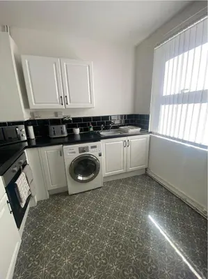 a small kitchen with a washing machine in it at No 6 - Home away from Home in Liverpool
