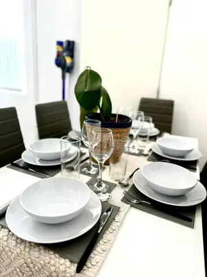 a table with white plates and glasses on it at No 6 - Home away from Home in Liverpool