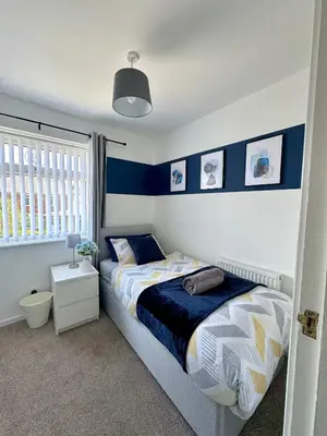 a bedroom with a bed with blue and white at Stunning Open Plan 3 Bed House - Driveway & Garden in Litherland