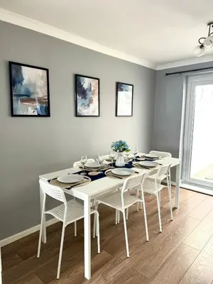 a white dining room with a white table and chairs at Stunning Open Plan 3 Bed House - Driveway & Garden in Litherland