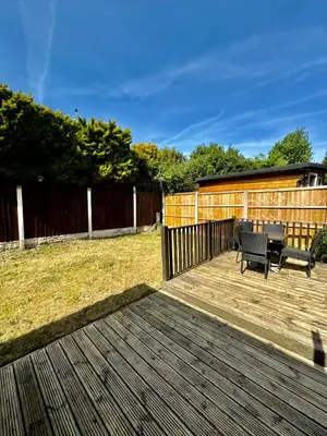 a patio with two chairs and a table on a deck at Stunning Open Plan 3 Bed House - Driveway & Garden in Litherland
