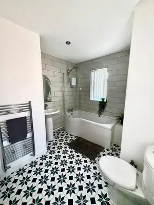 a bathroom with a tub and a toilet and a sink at Stunning Open Plan 3 Bed House - Driveway & Garden in Litherland