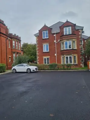 a white car parked in front of a brick building at 30 The Elms in Blackpool