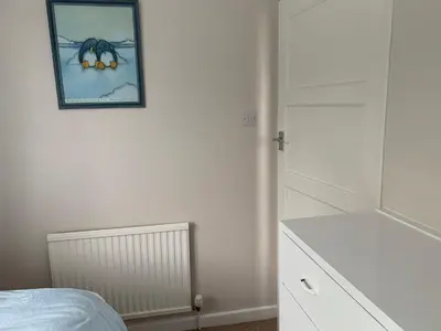 a bedroom with a picture of a spider on the wall at Hamilton Hideaway between Lancaster & Morecambe in Bare