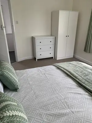 a bedroom with a large bed and a dresser at Hamilton Hideaway between Lancaster & Morecambe in Bare