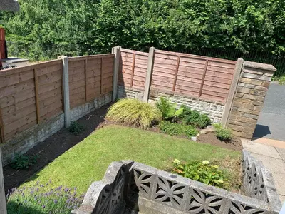 a wooden fence in a garden with grass at Hamilton Hideaway between Lancaster & Morecambe in Bare