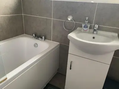 a bathroom with a sink and a bath tub next to a white sink at Hamilton Hideaway between Lancaster & Morecambe in Bare