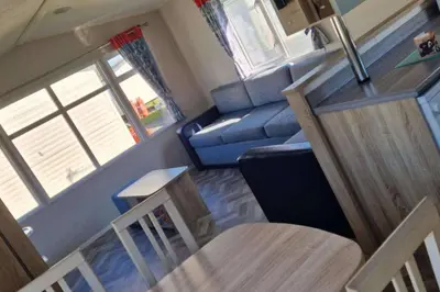 a living room with a blue couch and a table at Caravan-Blackpool-FamilyFriendly-Activities in Fleetwood