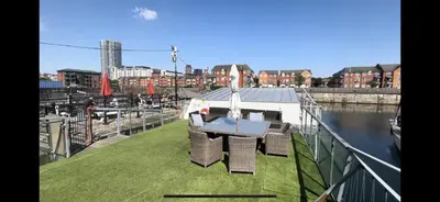 a balcony with a table on top of a boat at Float uniquely on Liverpool Waterfront on our high end 8 berth Houseboat in Liverpool