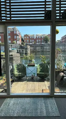 a window view of a patio with chairs and a table at Float uniquely on Liverpool Waterfront on our high end 8 berth Houseboat in Liverpool