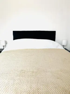 a bedroom with a bed with a comforter and two lamps at Walton Breck Road, Anfield LFC in Liverpool