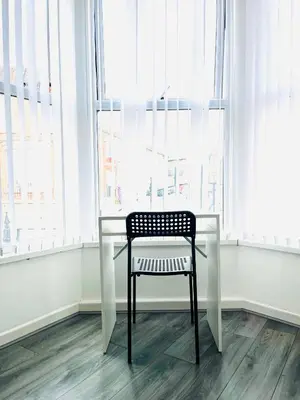 a chair sitting at a table in front of a window at Walton Breck Road, Anfield LFC in Liverpool