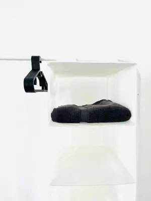 a white acrylic shelf with a black tool in it at Walton Breck Road, Anfield LFC in Liverpool