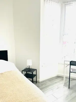 a bedroom with a bed and a table and a window at Walton Breck Road, Anfield LFC in Liverpool
