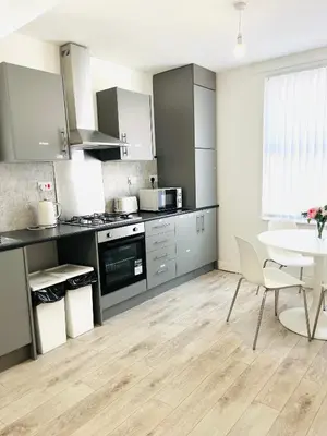 a kitchen with stainless steel appliances and a table at Walton Breck Road, Anfield LFC in Liverpool