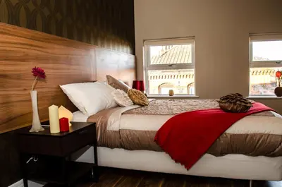 a bedroom with a bed with a red blanket on it at Trivelles Liverpool in Liverpool