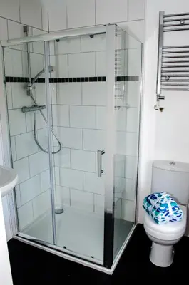 a glass shower in a bathroom with a toilet at Trivelles Liverpool in Liverpool