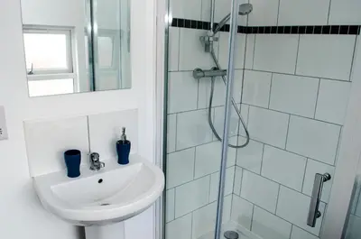 a white bathroom with a sink and a shower at Trivelles Liverpool in Liverpool