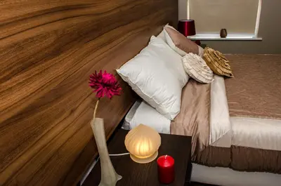 a bedroom with a bed with a vase with a flower on a table at Trivelles Liverpool in Liverpool