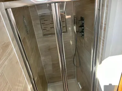 a shower with a glass door in a bathroom at Entire Seaside Home 6 Private BedRooms Sleeps 10,4 Minute Walk To Station in New Brighton