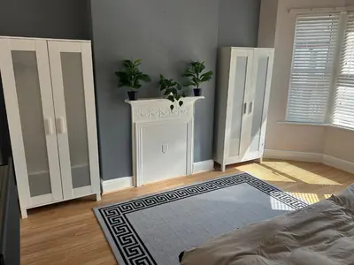 a bedroom with white cabinets and potted plants on top at Entire Seaside Home 6 Private BedRooms Sleeps 10,4 Minute Walk To Station in New Brighton