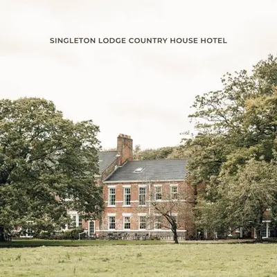 a large brick building with trees in front of it at Singleton Lodge Country House Hotel in Poulton le Fylde