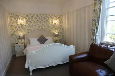 a bedroom with a white bed and a couch at Singleton Lodge Country House Hotel in Poulton le Fylde