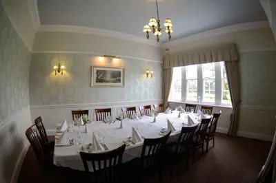 a dining room with a long table and chairs at Singleton Lodge Country House Hotel in Poulton le Fylde