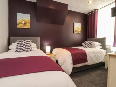 a hotel room with two beds and a window at 7-Bed Beachside Retreat - Sleeps 14 & Pet Friendly in Blackpool