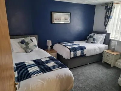 two beds in a room with blue walls at 7-Bed Beachside Retreat - Sleeps 14 & Pet Friendly in Blackpool