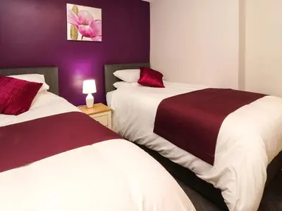 two beds in a room with purple walls at 7-Bed Beachside Retreat - Sleeps 14 & Pet Friendly in Blackpool