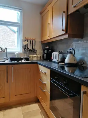 a kitchen with wooden cabinets and a tea kettle at Aqua View, New Brighton Beach - 1 bedroom with BALCONY & VIEW in New Brighton
