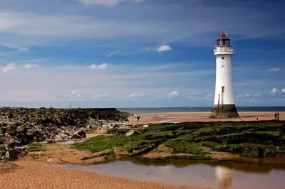 a lighthouse on a beach next to a body of water at Aqua View, New Brighton Beach - 1 bedroom with BALCONY & VIEW in New Brighton